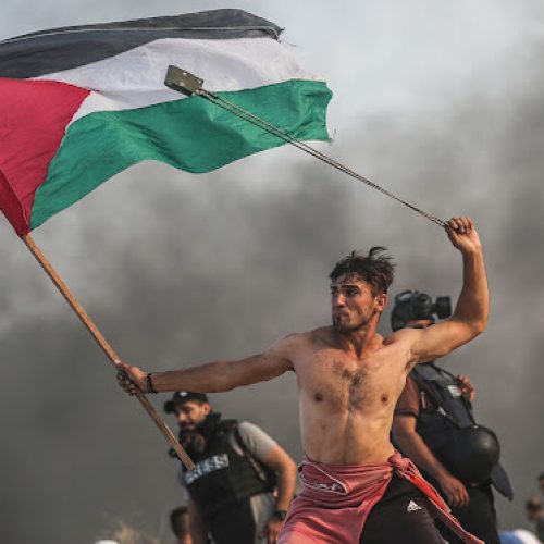GAZA CITY, GAZA - OCTOBER 22: Palestinians throw stones and burn tyres in response to Israeli forces' intervention as they gather to support the maritime demonstration to break the Gaza blockade by sea with vessels in Gaza City, Gaza on October 22, 2018. (Photo by Mustafa Hassona/Anadolu Agency/Getty Images)